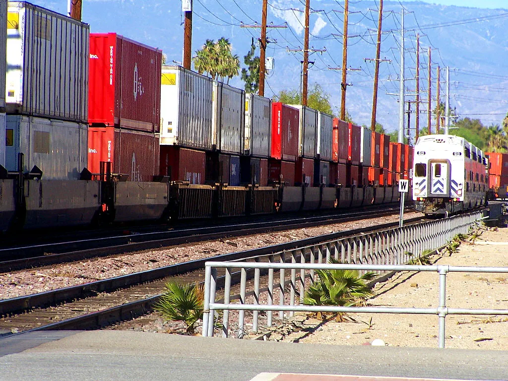 Some connected trainwagons each loaded with two shipping containers