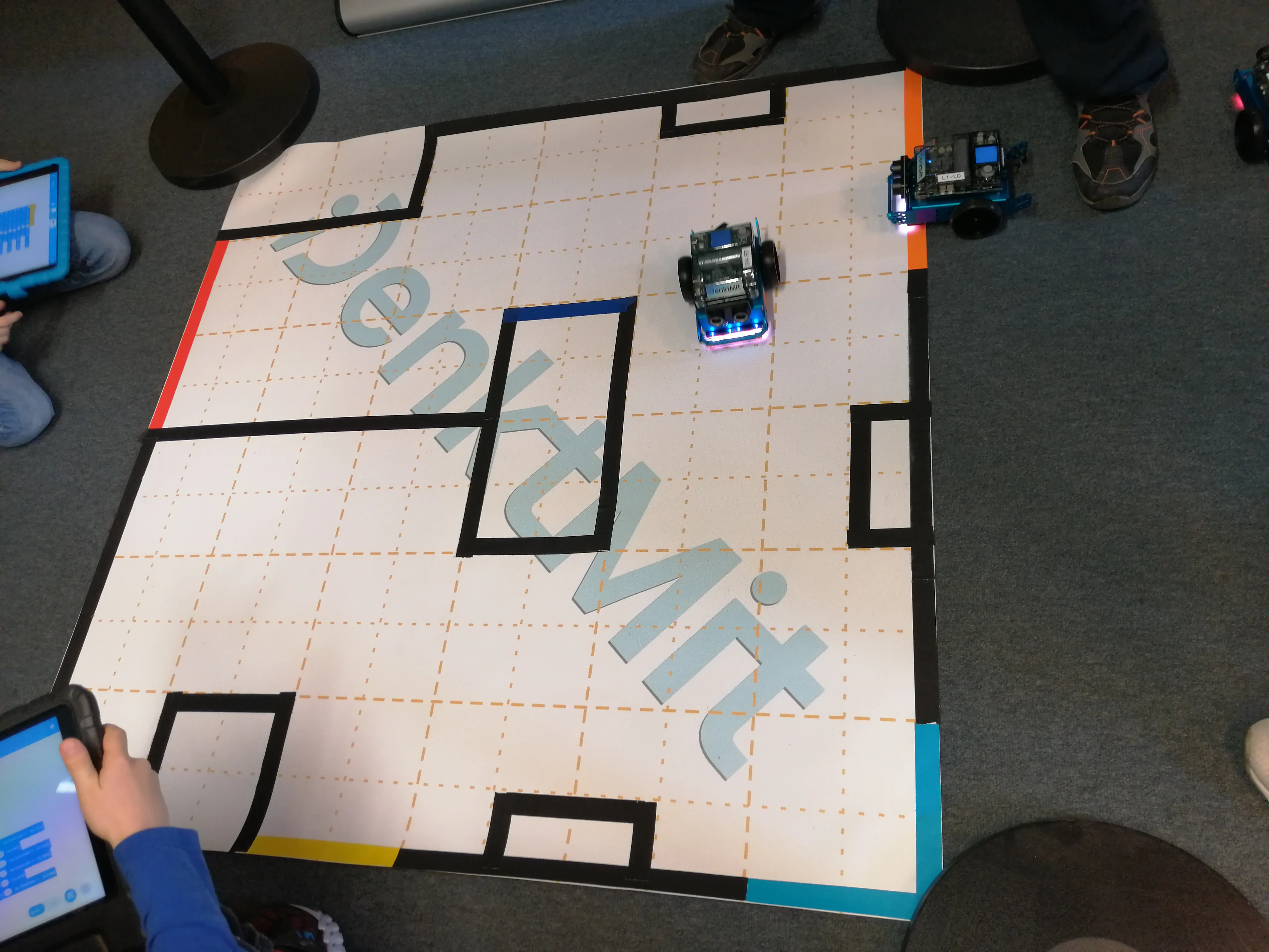 Kinder, die mittels Programmierung auf iPads ihre mBot2 durch ein Labyrinth steuern